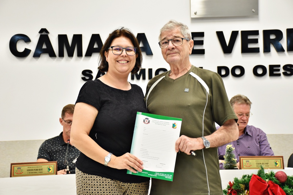 Ascom/Câmara de Vereadores de SMOeste - Maria Tereza Capra entregou cópia do projeto de lei a Garibaldi Barichello, viúvo da homenageada Pierina Ferronatto Barichello