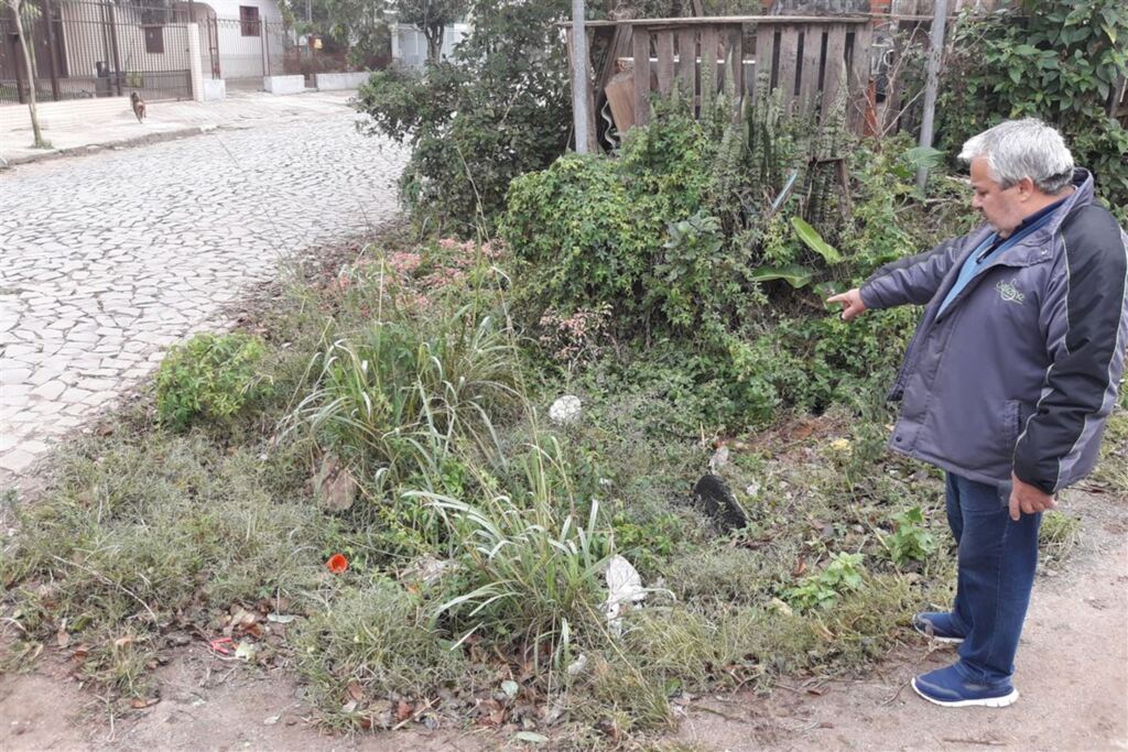 Foto: Rafael Favero (Diário) - Júlio Couto mostra o local em que uma boca de lobo foi inutilizada pelo mato, lixo e terra