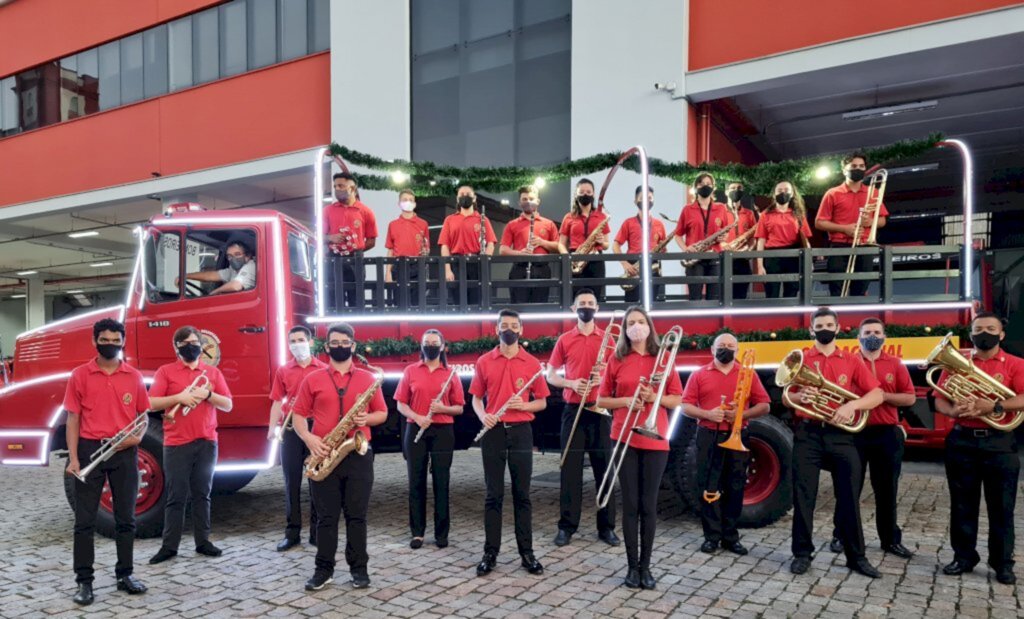 Banda dos Bombeiros leva música pela cidade em caminhão iluminado