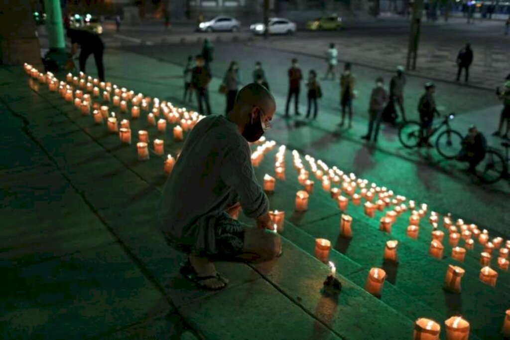 REUTERS/Pilar Olivares - Pessoas acendem velas no Rio de Janeiro em homenagem aos mortos pela Covid-19