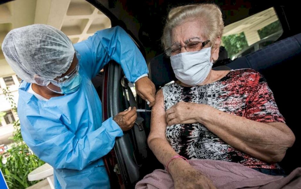 Futura Press - Dona Margarete Sequeira de 87 anos de idade, residente da cidade de Niterói (RJ), recebe sua segunda dose da vacina CoronaVac no Drive-Thru do campus do UFF - Gragoatá