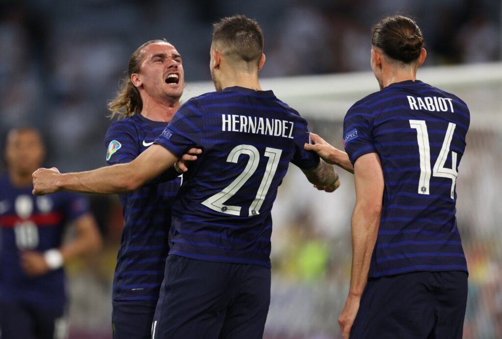 Griezmann e Hernández comemoram o gol do jogo, que teve cruzamento do segundo para toque contra de Hummels
