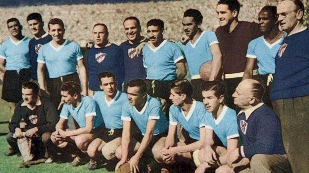 Foto: Wkipédia - A Seleção Uruguaia posando antes da partida decisiva contra o Brasil em 1950. Em pé, da esquerda para a direita, estão Varela, o técnico López, Tejera, dois membros da delegação, Gambetta, Matías González, Máspoli, Rodríguez Andrade e outro membro da delegação; agachados, entre outros dois delegados, estão Ghiggia, Julio Pérez, Míguez, Schiaffino e Morán.