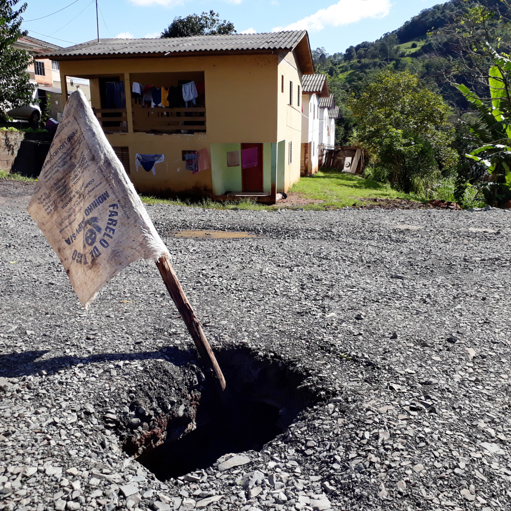  - Loteamento Maximiliano Toaldo, ruas Carmelo Zoccoli e Devino Fracasso serviços prestados e dias depois os tubos quebraram, devido pouco cascalho por cima dos mesmos, ou quem sabe, deveria ter uma camada de concreto ou asfalto com armação de ferro, pois, deu sorte nenhum veículo cair para dentro da tubulação. A sorte que alguém teve a ideia de colocar um pau com um saco de rafia, no sentido de alerta.