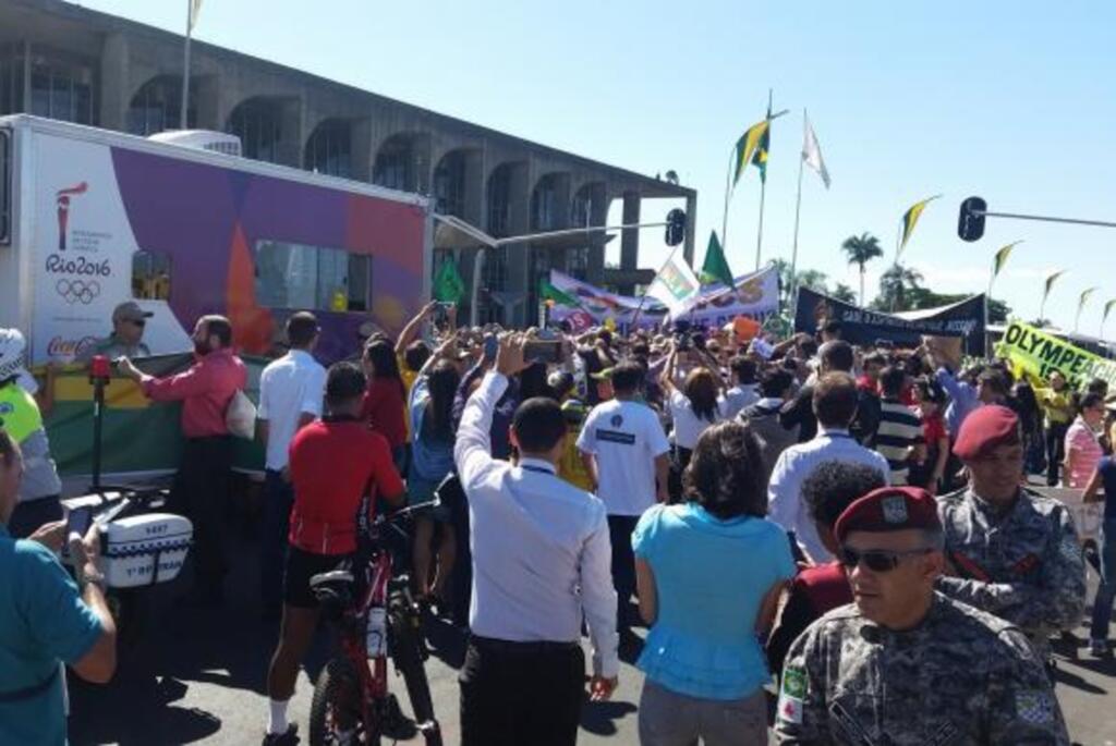 Revezamento da tocha na Esplanada é acompanhada por manifestantes