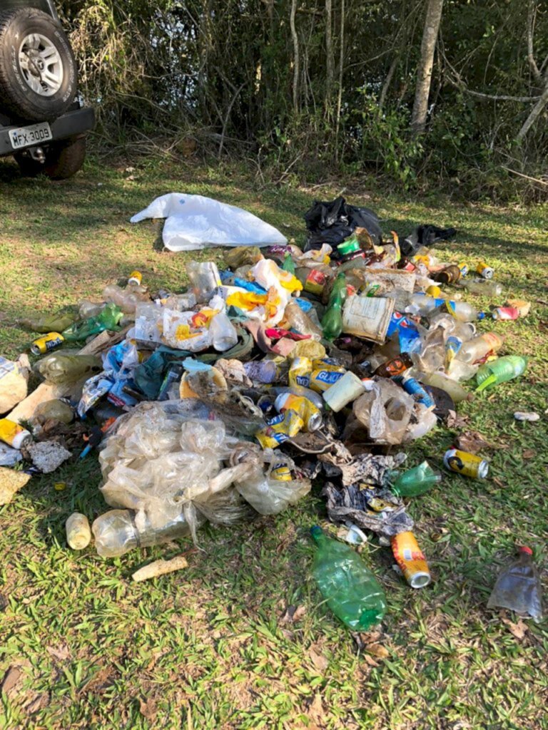 Voluntários recolhem lixo em mata ciliar à beira do rio Uruguai