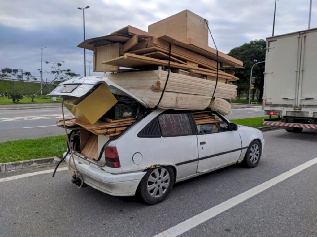 Motorista 'some' dentro de carro lotado de móveis