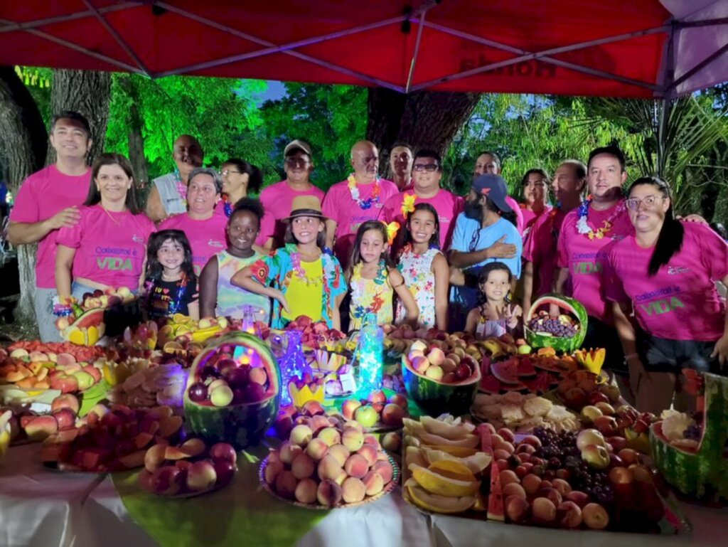 Divulgação - Mesa de frutas do Happy hour Hawai e alguns membros da diretoria do clube