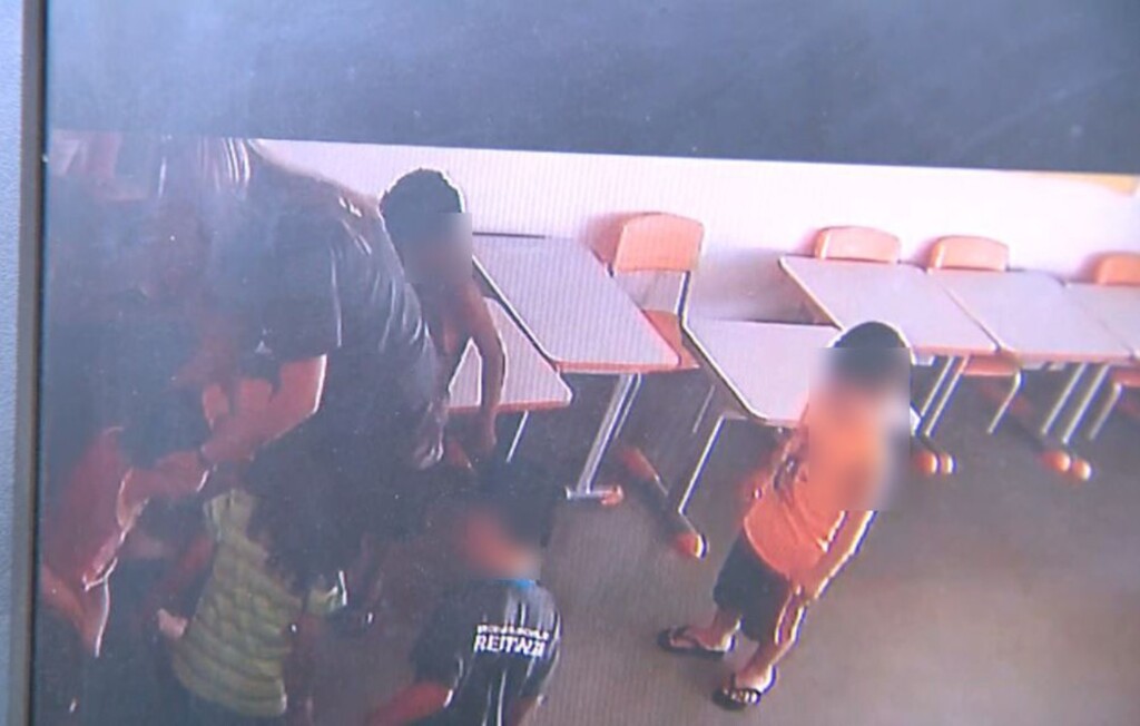  - No canto esquerdo, a estagiária segura a criança, enquanto a professora tentar puxar o saco e fechá-lo em Restinga, SP (Foto: Câmeras de segurança)