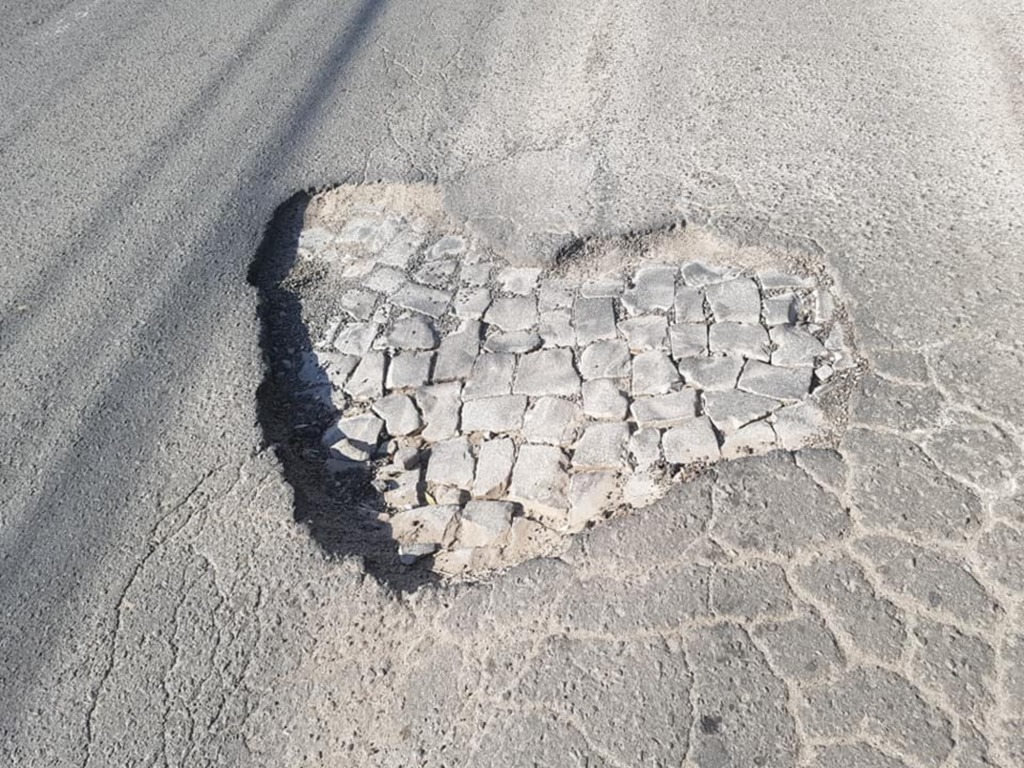 Foto: Valdir Oliveira (Reprodução/Facebook) - Cratera romântica em rua no bairro Tancredo Neves