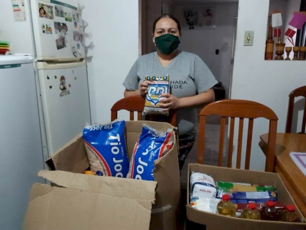 Voluntárias confeccionam máscaras em troca de doação de alimentos