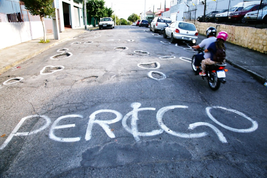 VÍDEO: moradores pintam 199 buracos para denunciar situação de rua