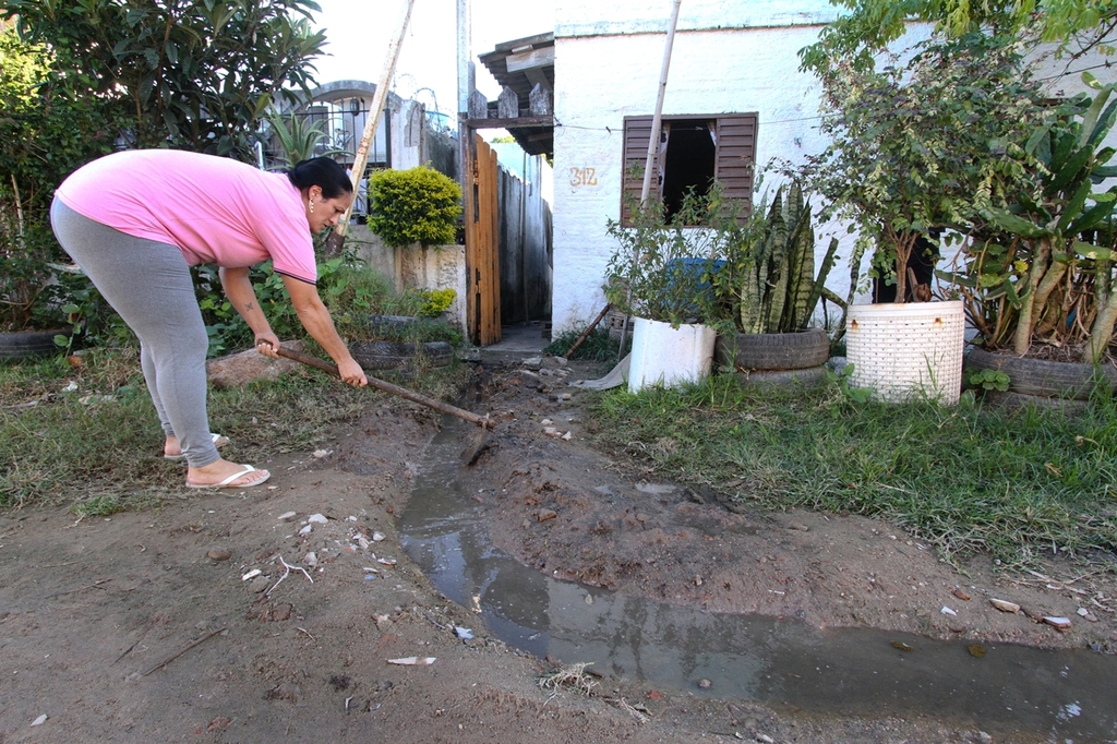 Foto: Carlos Queiroz - DP - Viviane precisa escavar diversas vezes uma espécie de valeta na porta de casa para escoar o esgoto