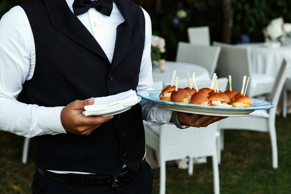  - Waiter carries plate with tasty snacks