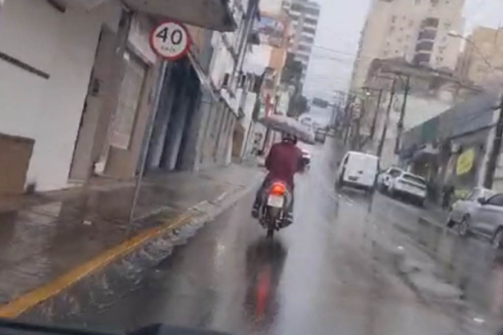 título imagem VÍDEO: motociclista é flagrado dirigindo com guarda-chuva no Centro de Santa Maria