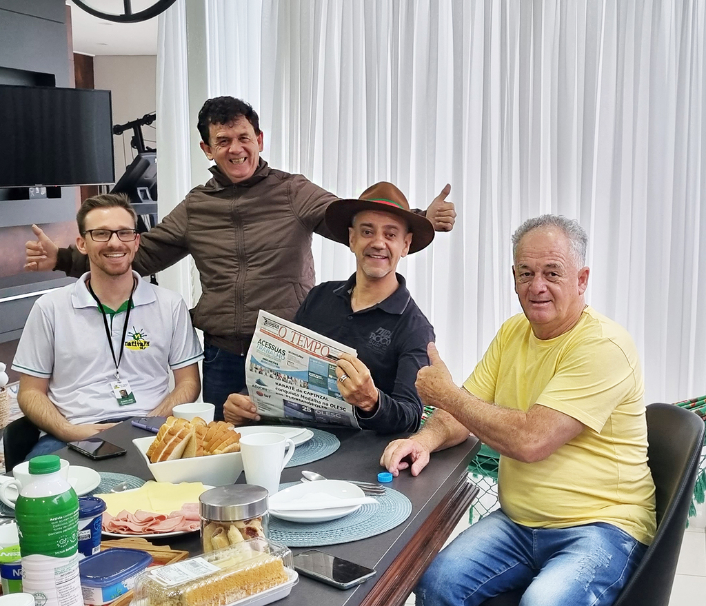  - Foto legenda: Magrão entre Álvaro, Aldo e Enio, mostrando uma das raridades, sendo O TEMPO jornal de fato em mais uma edição.