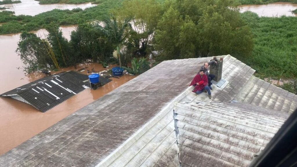 Muitas pessoas aguardavam por ajuda nos telhados das casas (Foto: PMSC, Divulgação) - 