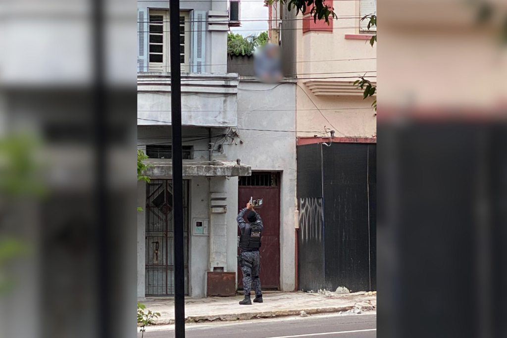 Foto: Reprodução - Policial militar aponta arma para suspeito, que subiu em marquise de casa na Avenida Rio Branco para tentar fugir na tarde desta quarta-feira